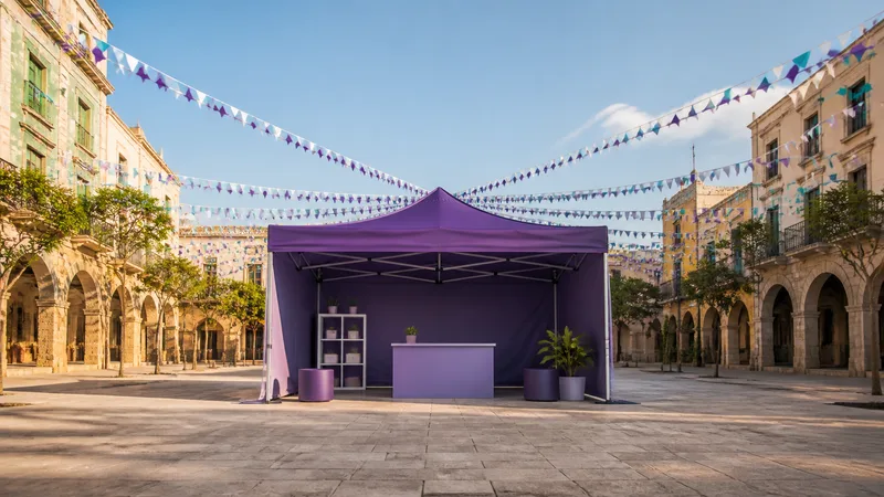 Carpa violeta informativa instalada en una plaza de fiesta mayor antes de abrir al público