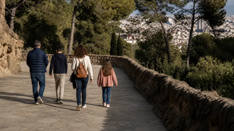 Familia recorriendo un camino de piedra y mosaico del Park Güell con calma
