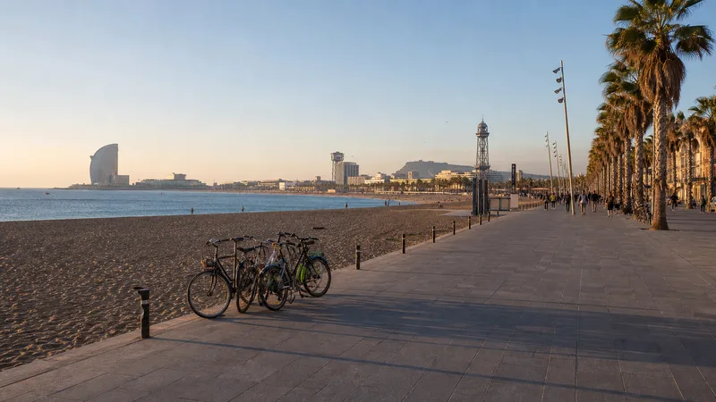 Paseo marítimo de la Barceloneta con bicicletas, arena y mar al final de la tarde