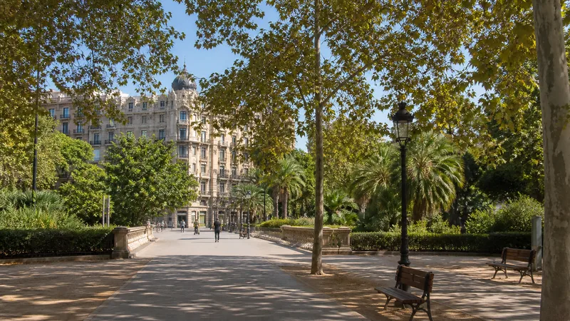 Paseo arbolado en la entrada del parque de la Ciutadella con bancos y palmeras