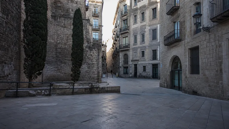 Plaza de piedra y calles enlazadas del Barri Gòtic a primera hora de la mañana