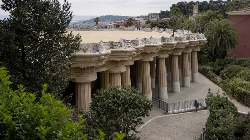 Sala hipóstila y terraza elevada del Park Güell entre vegetación mediterránea