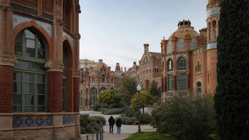 Patio ajardinado entre pabellones de ladrillo y cerámica del Recinte Modernista de Sant Pau