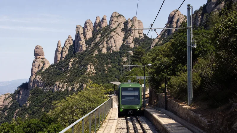 Tren de cremallera en una estación de montaña frente al macizo de Montserrat