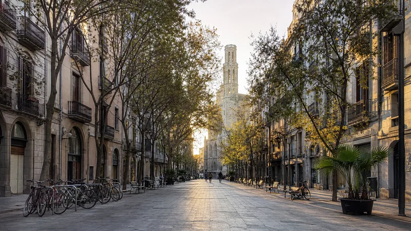 Paseo arbolado del Born con fachadas históricas y una iglesia de piedra al fondo