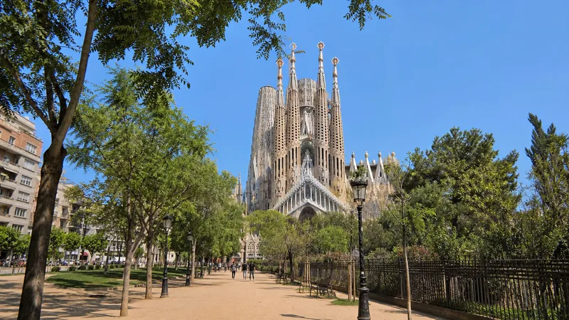 Sagrada Família al fondo de la avenida de Gaudí durante una mañana clara en Barcelona