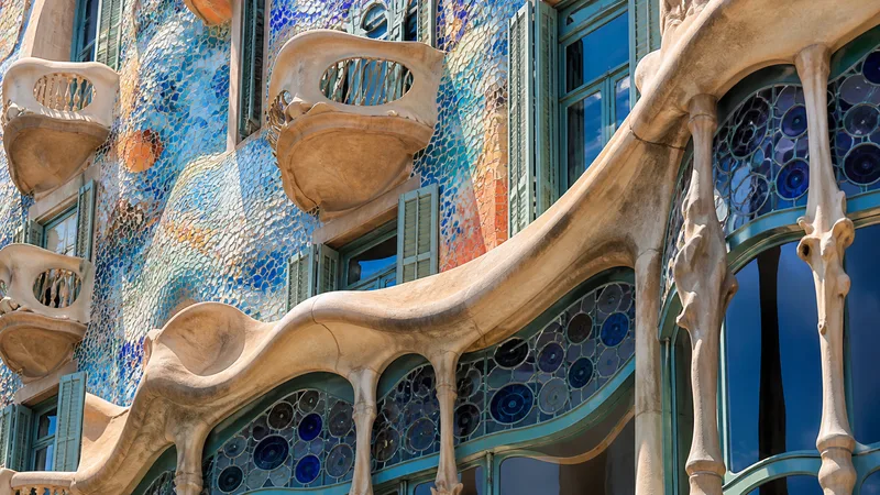 Fachada editorial ondulante con mosaico y balcones inspirada en Casa Batlló, sin personas