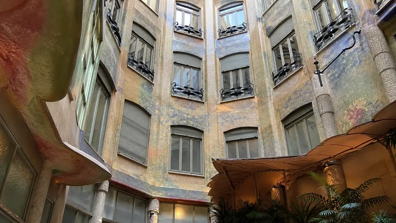Patio interior de la Pedrera visto desde la planta baja, con fachada ondulada, balcones y pintura mural
