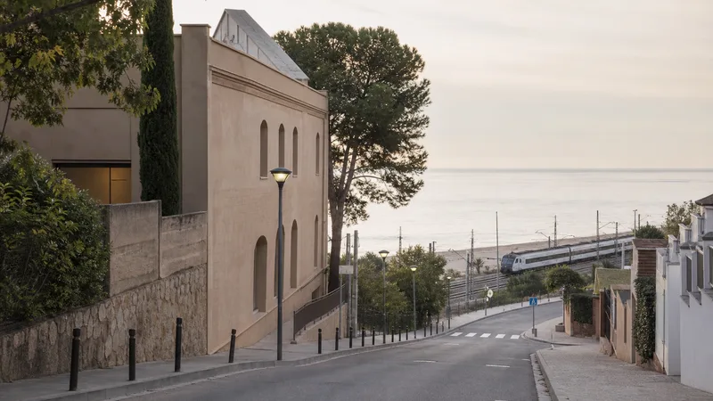 Centro cultural en una calle de Caldes d’Estrac que desciende hacia tren y mar