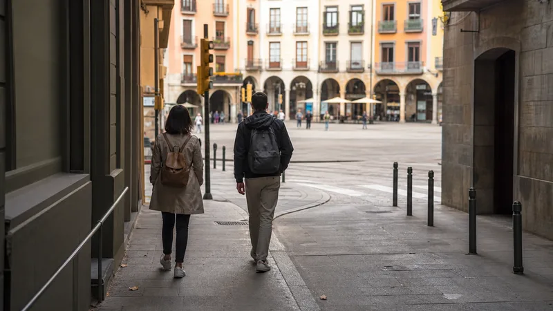 Dos viajeros llegando a pie a la plaza porticada de Vic