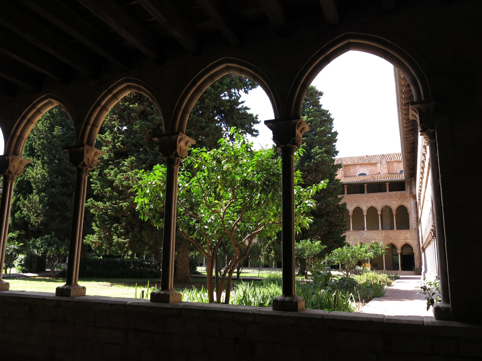 Arcos del claustro de Pedralbes con el jardín y las galerías al fondo