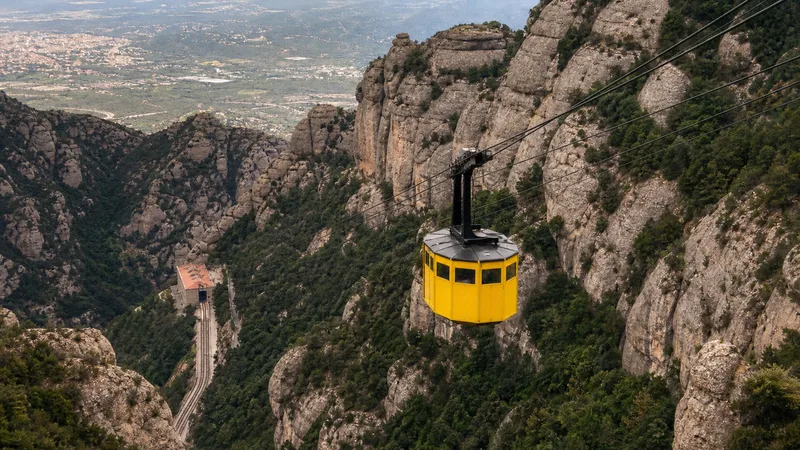 Cabina amarilla del Aeri de Montserrat suspendida sobre el valle y las paredes de conglomerado
