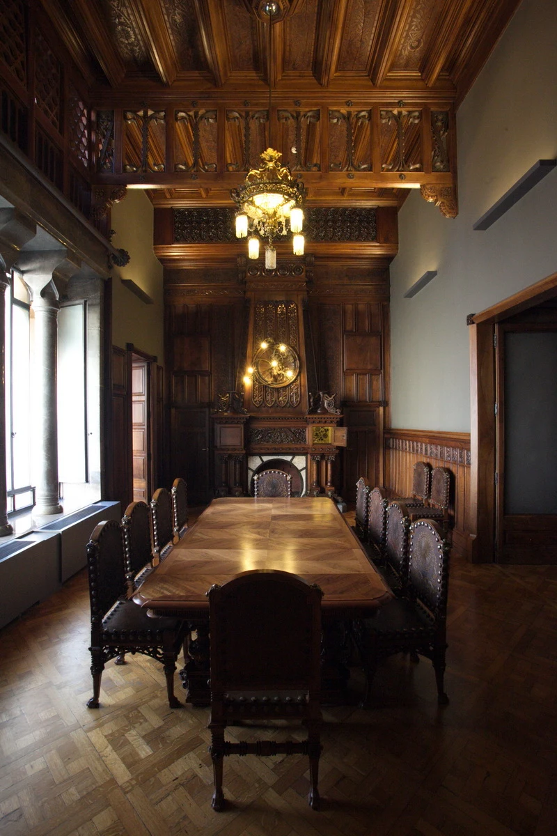 Mesa, sillas, chimenea y artesonado del comedor del Palau Güell