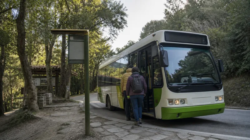 Autobús público rural en una parada habilitada del Montseny, con dos pasajeros de espaldas