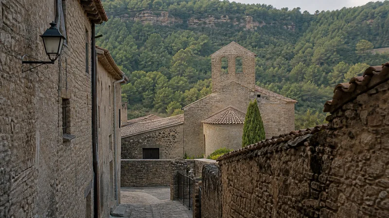 Calle de piedra e iglesia románica de Mura entre bosques de Sant Llorenç