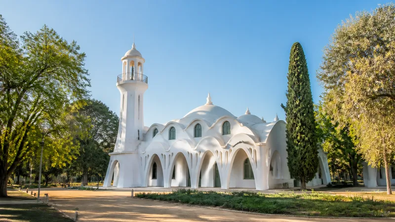 Masia Freixa de formas blancas ondulantes y arcos parabólicos en un parque