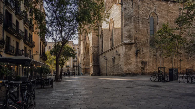 Plaza peatonal arbolada junto a una iglesia gótica de piedra en el Born